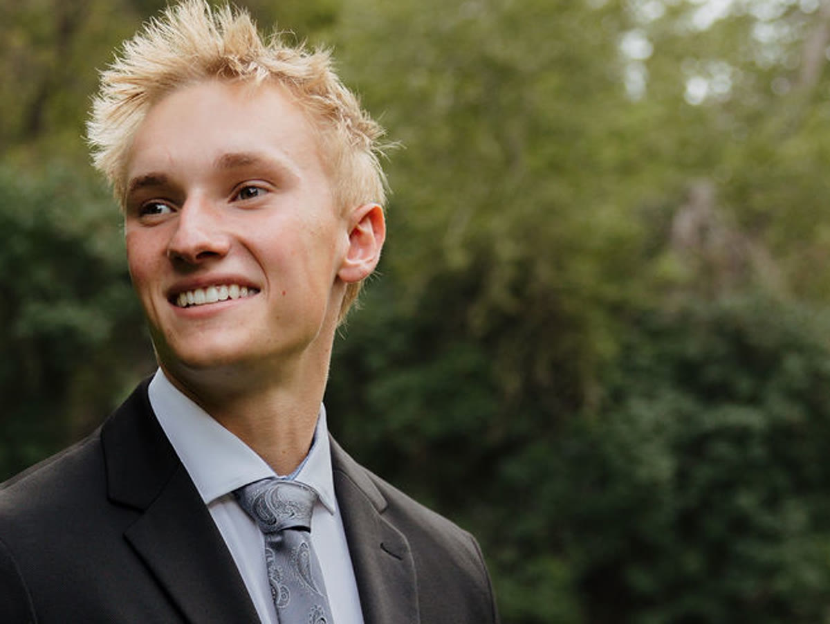 Elder Brigham Larson smiling, Louisiana flag over his arm